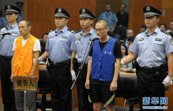 9月16日,被告人韩磊(右,李明在庭审中.新华社记者公磊 摄